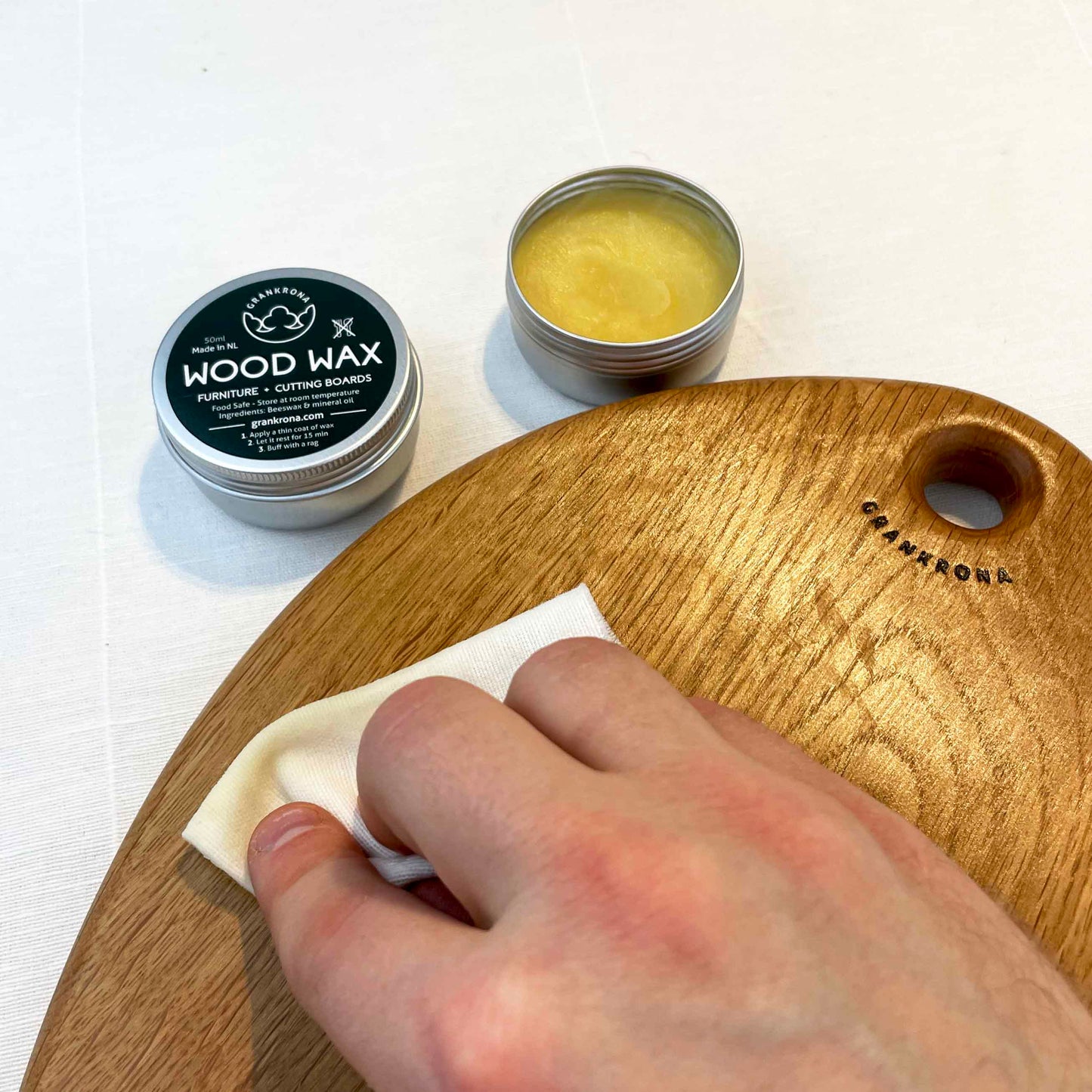 hand buffing a wooden cutting board with wood wax by grankrona