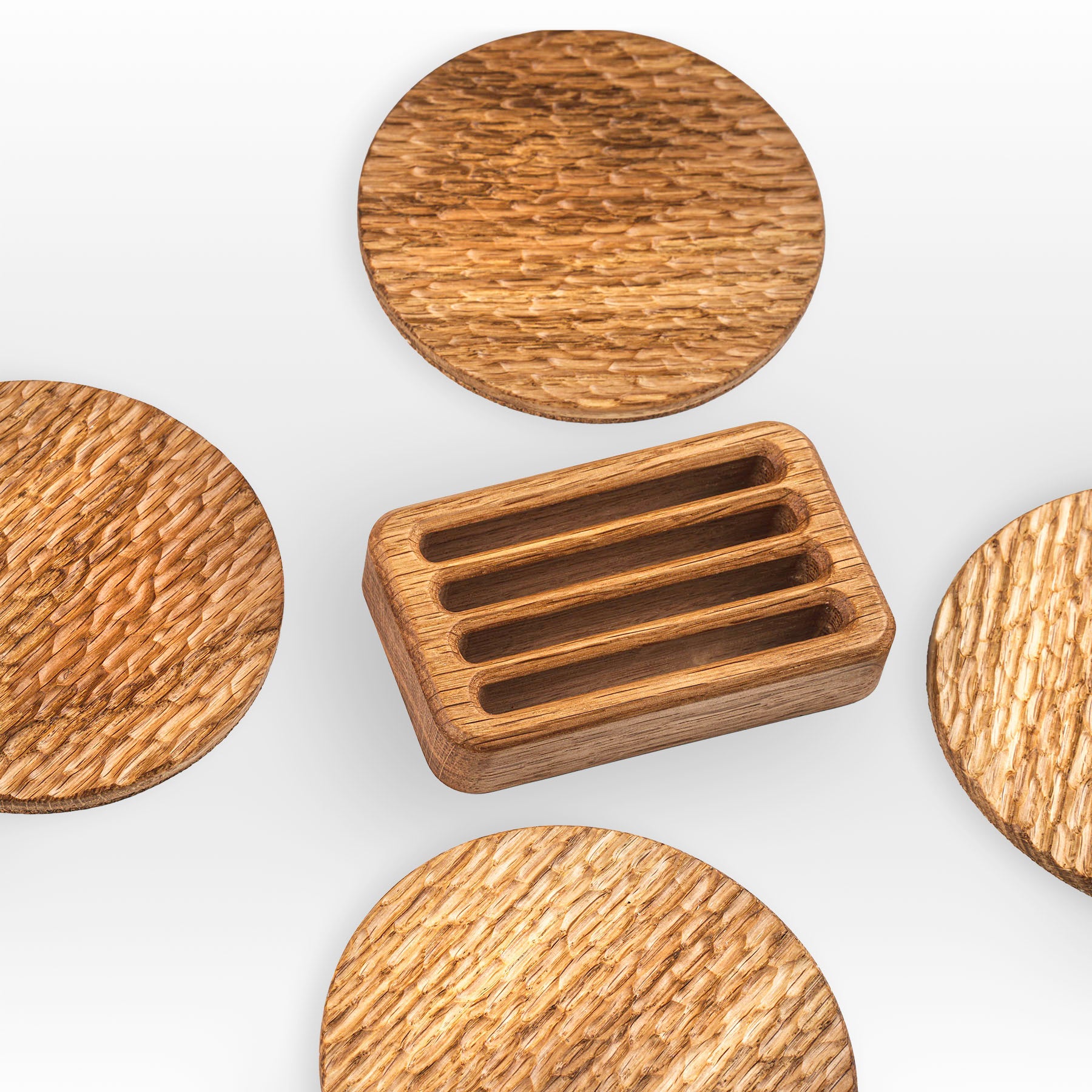 'Bark' wood coasters made from oak spread out around the holder in the middle