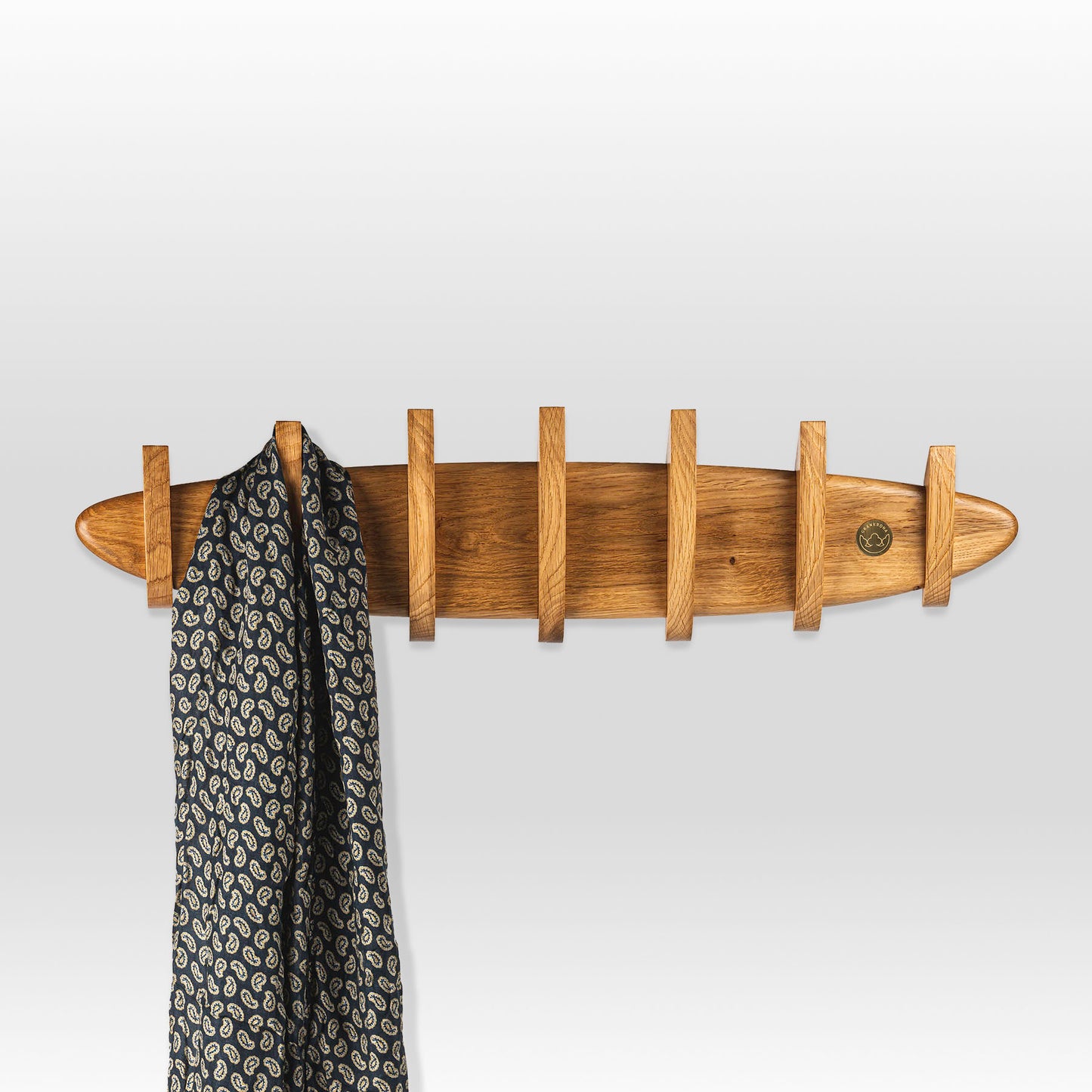 'Krona' coat hanger by grankrona in oak wood and with a scarf hanging on one of its hooks